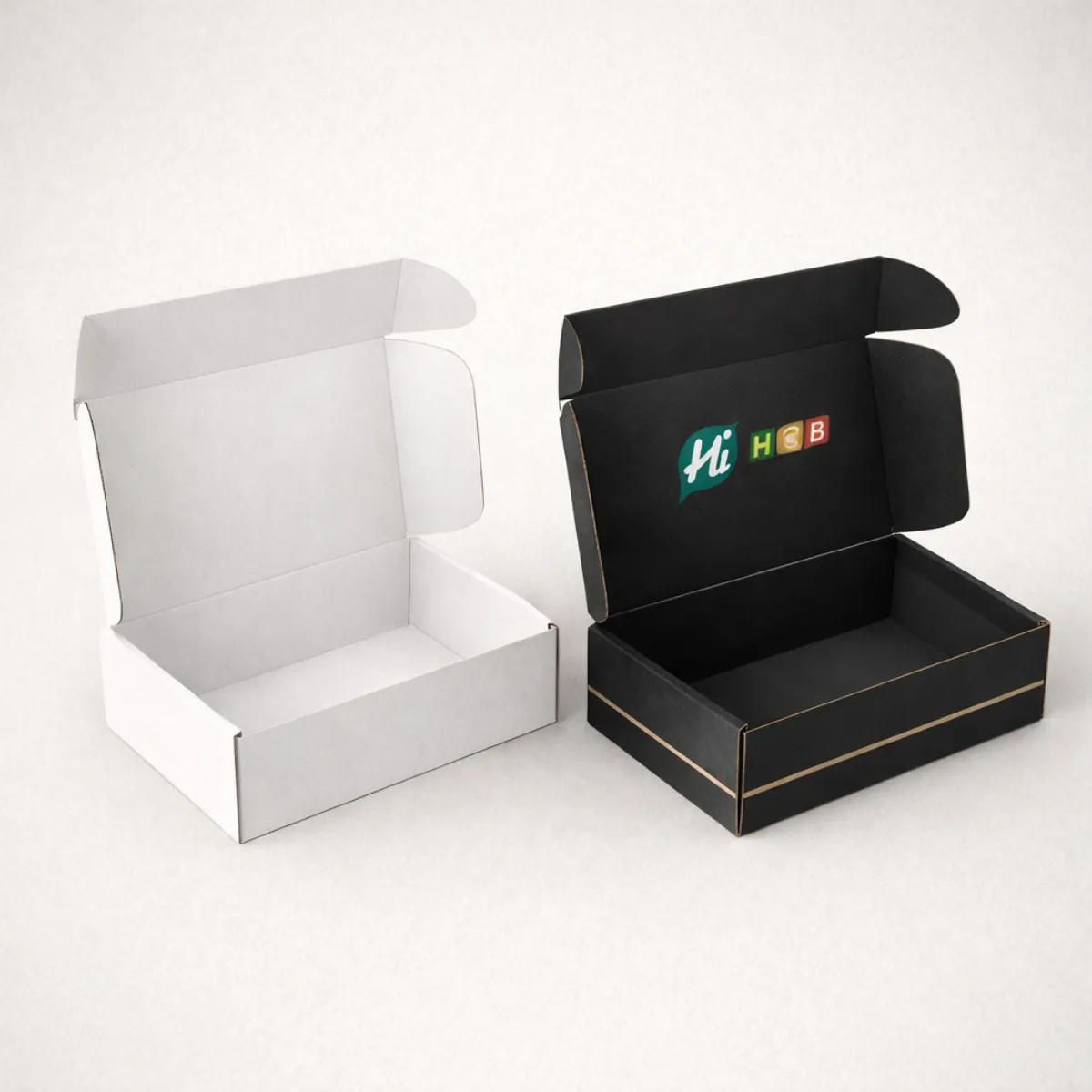 Open cardboard mailer boxes shown in white and black- featuring internal branding and thin gold lines-